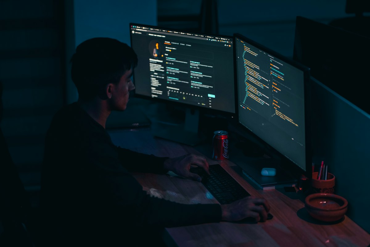 Developer reviewing code on a dual-monitor setup