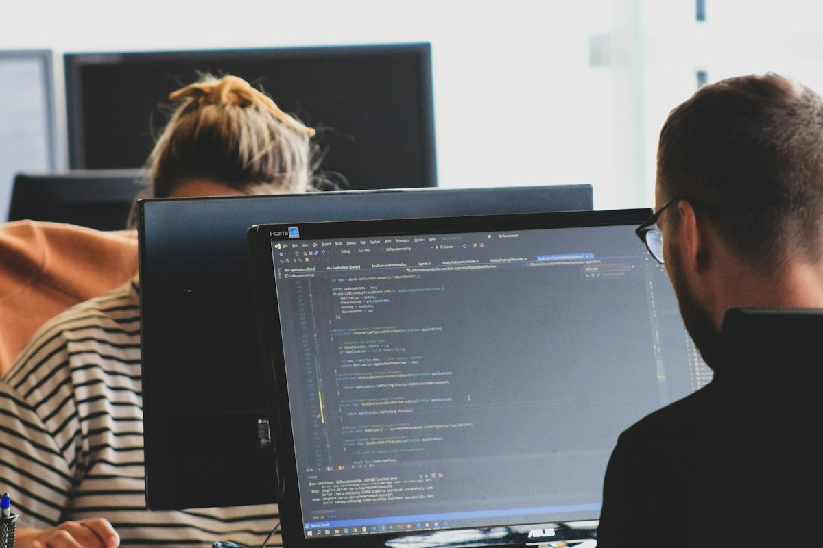 Developers working at a dual-monitor workstation